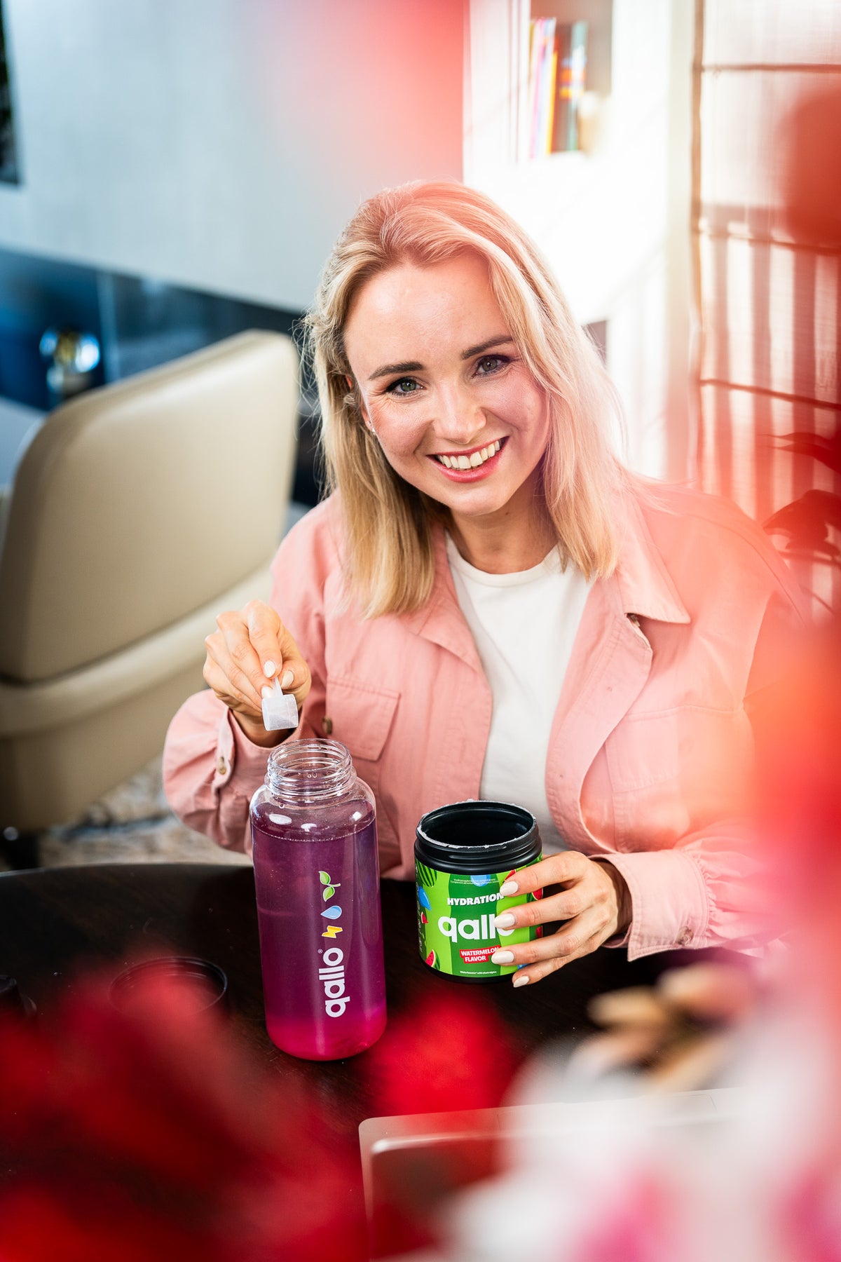 Vrouw schept Qallo Hydration Watermelon uit een pot in haar drinkfles