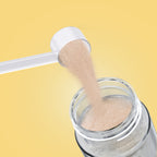 Scoop of Qallo Vitamins Pineapple powder poured into a bottle